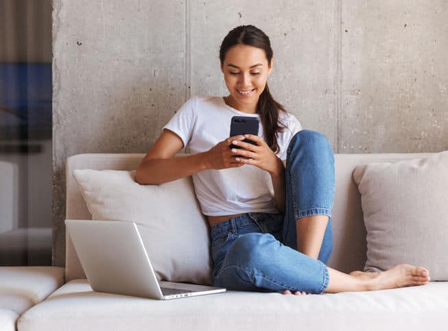 a woman sitting on a couch using a phone